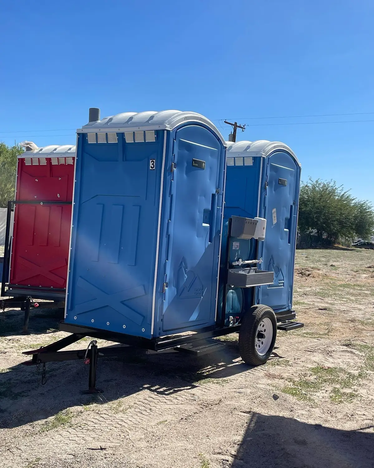 Porta potties loaded on a delivery trailer at a job site
