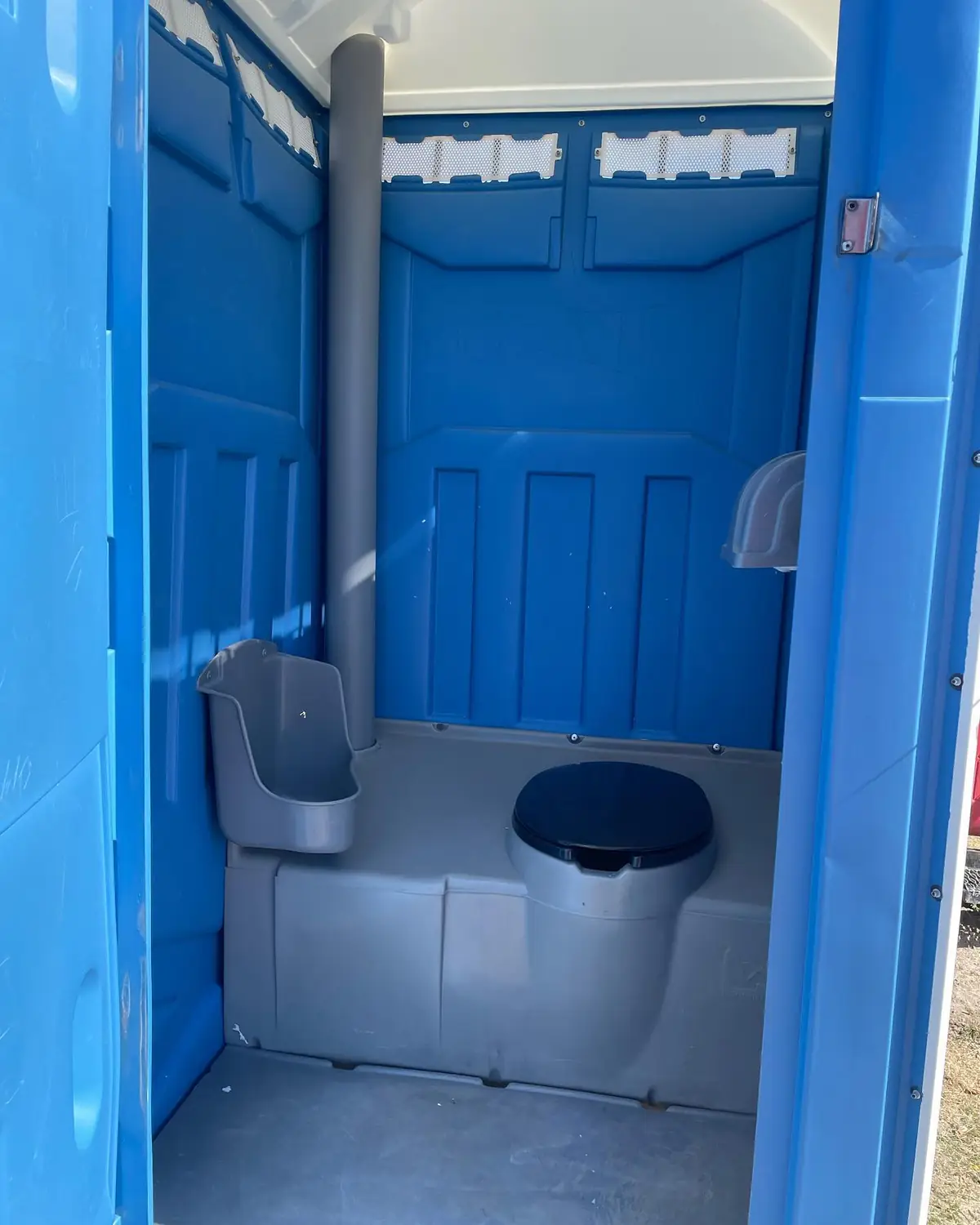 Standard unit interior: toilet seat, urinal, toilet paper and sanitizer