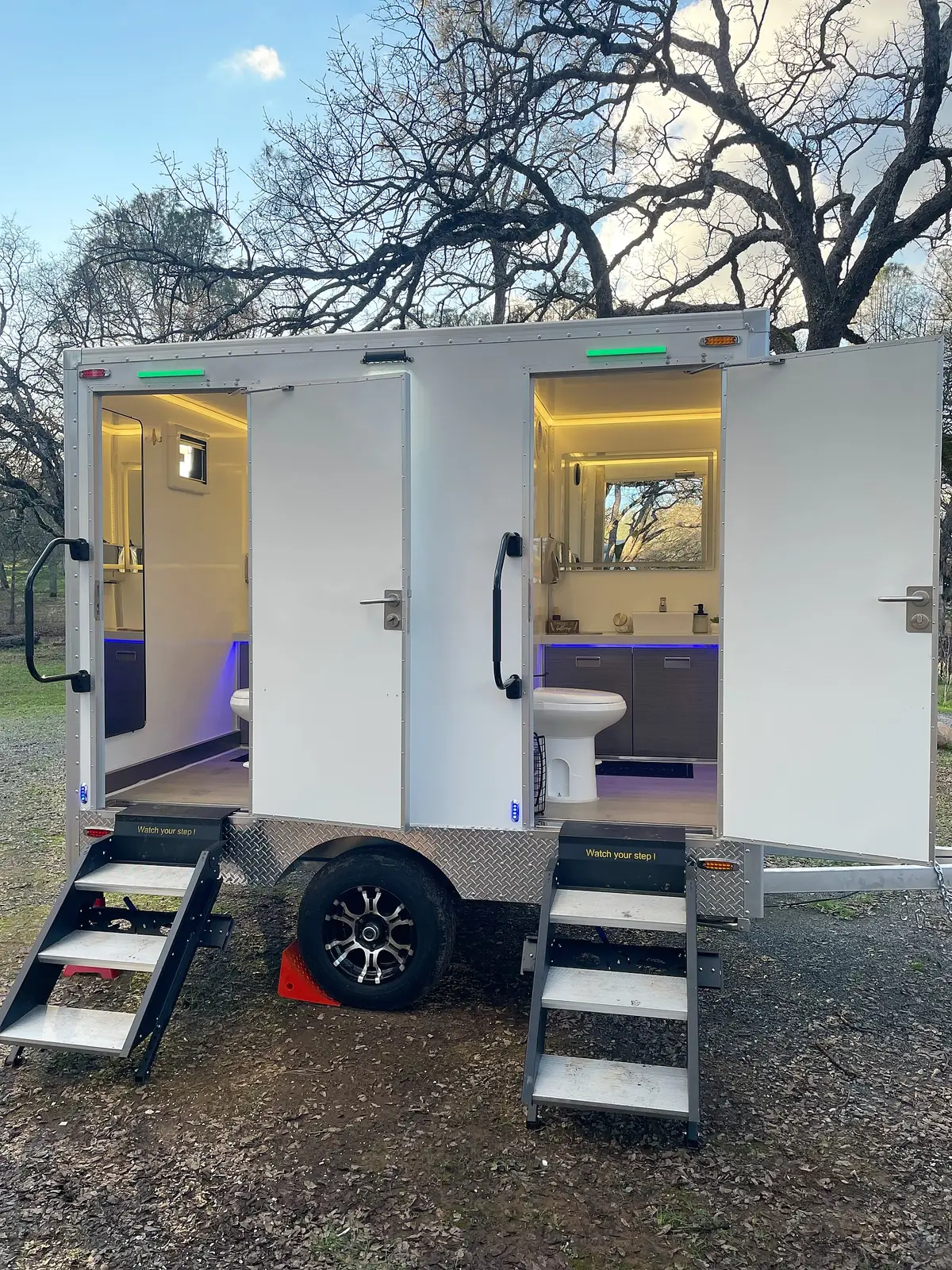 Inside a VIP restroom trailer with lights on during an evening event